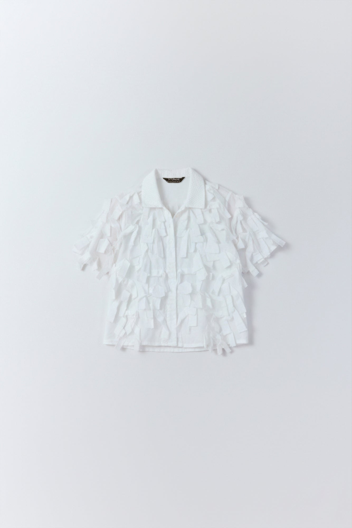 Flat lay of Yaccomaricard of Hane Shirt  adorned all over with a plumage of raw-edged ribbons.