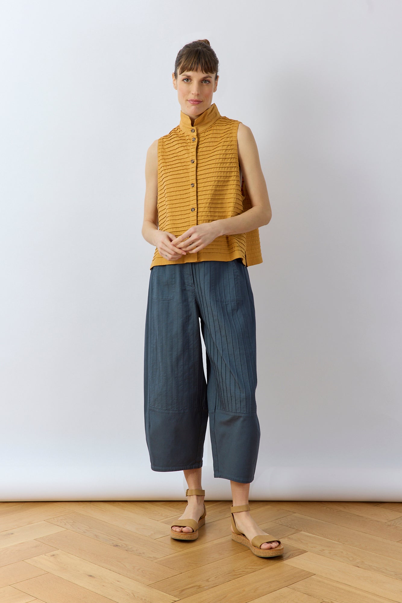 Shot of a model wearing Brown Sugar Kantan Jersey Waistcoat by Yaccomaricard, showing its boxy fit.