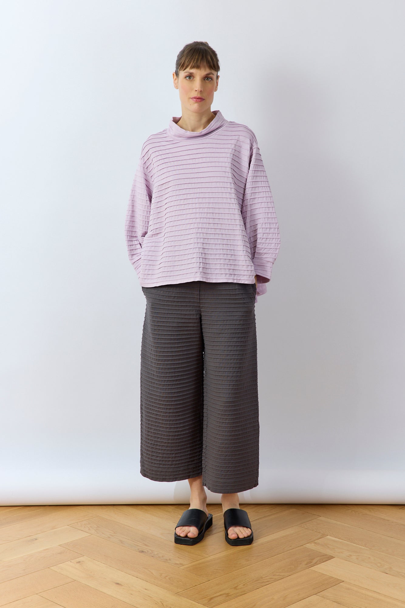 Full length view of the Sode Jersey Pullover in Lilac Purple with cotton jersey trousers.