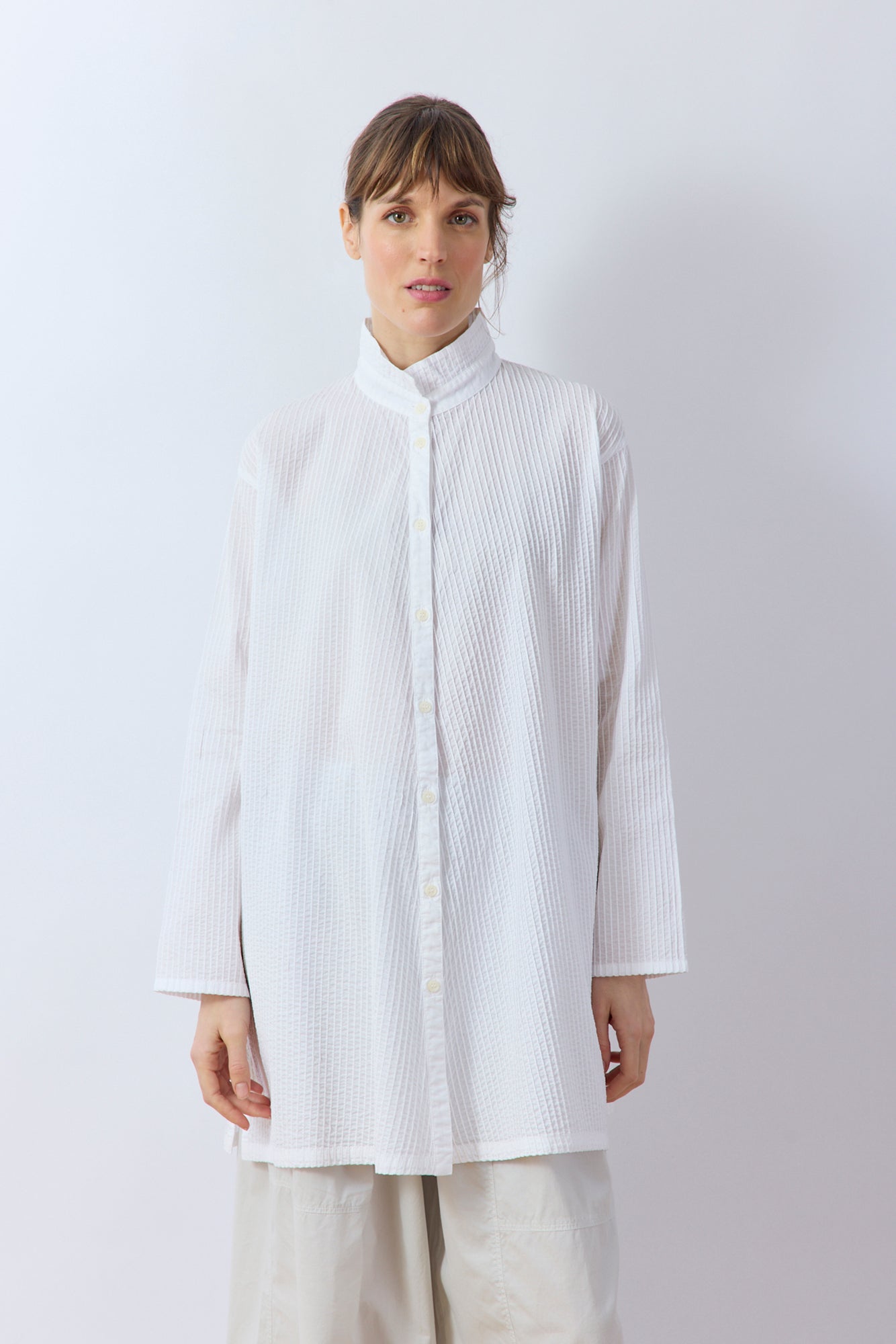 Front of the signature diagonal pintuck  on the White cotton lawn Tunic Shirt by Yaccomaricard Sppring Summer 26.