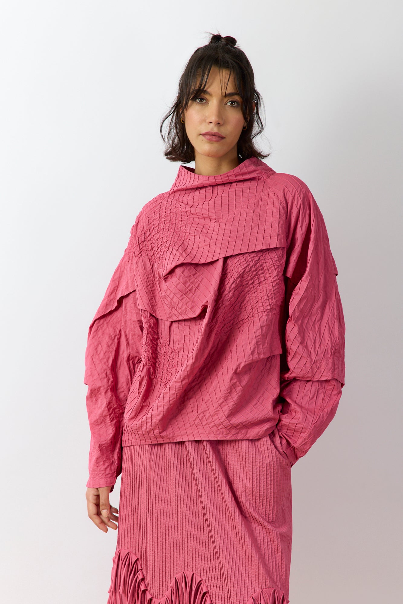 Front view of the Yaccomaricard 1023998 pintuck top in Dust Rose, featuring a relaxed A-line silhouette, high neckline, and the brand's signature all-over vertical pintuck detailing.