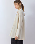 Side profile of the Jasmine White Cotton Lawn Overshirt showing the longline silhouette and side vents.