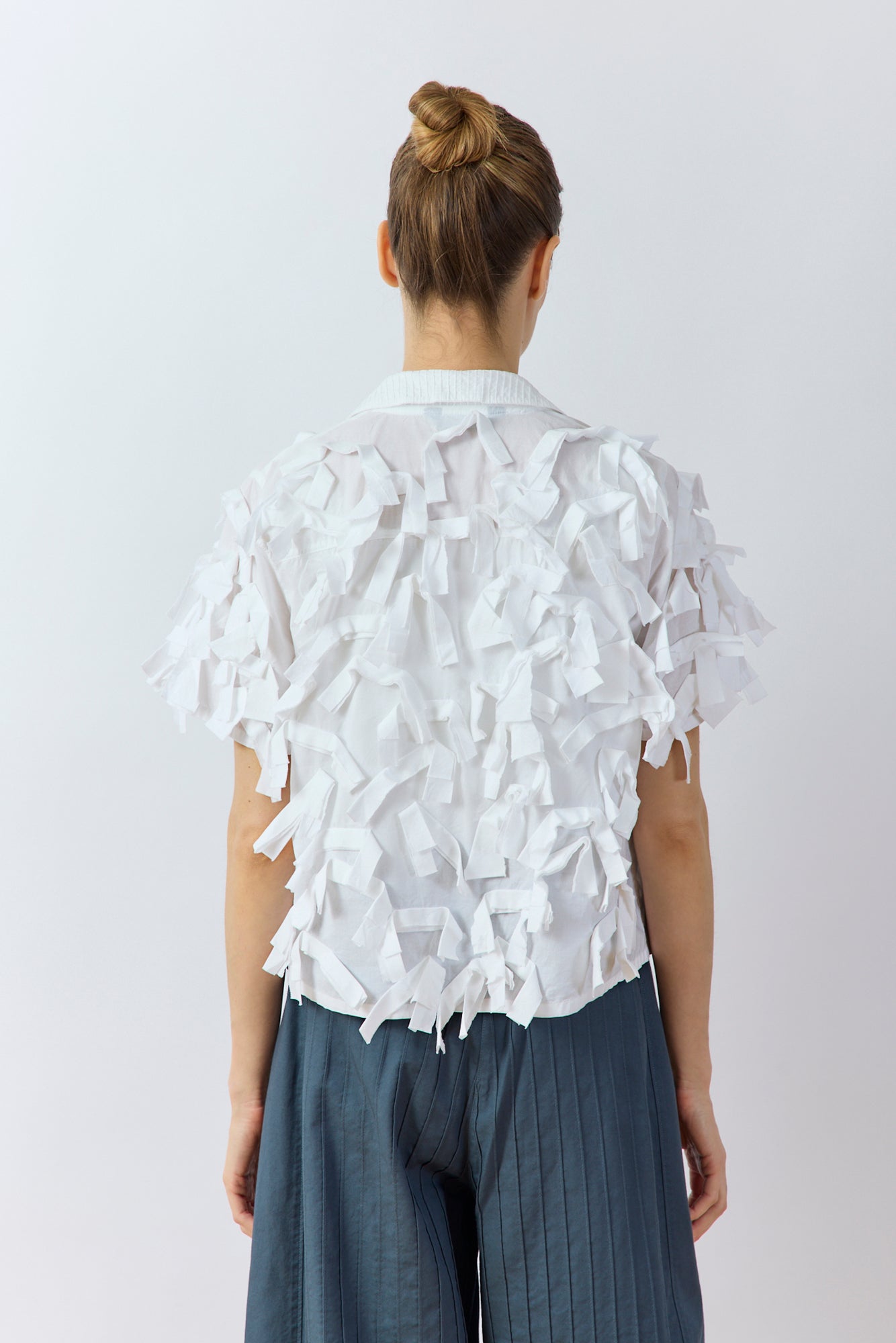 Back view of Yaccomaricard Hane Shirt in white highlighting the bias-cut cotton ribbon plumage.
