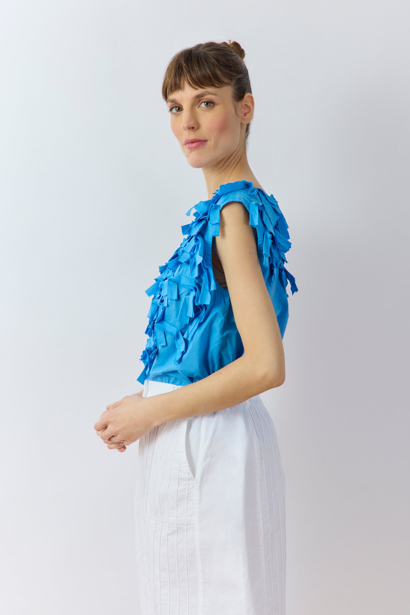 Side profile of the Hane Vest in Hana Blue showing the relaxed fit and raw-edged lawn ribbons by Yaccomaricard.