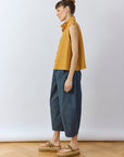 Side profile of the Stone Blue Obaru Trouser showing the architectural three-panel construction and contoured fit.
