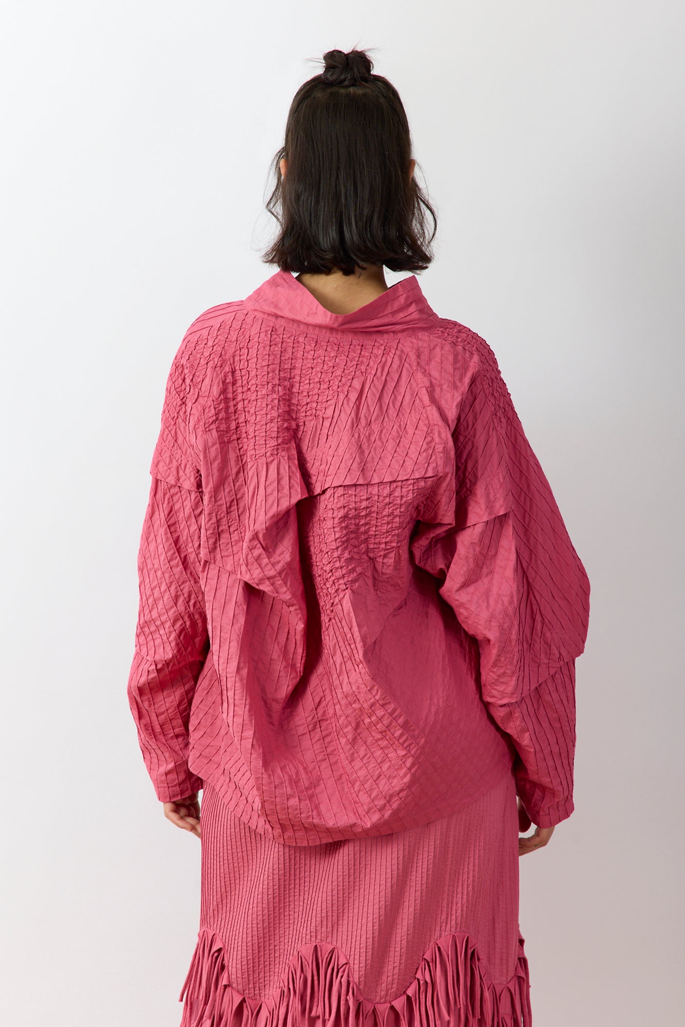 Back view of the Yaccomaricard pintuck Shibo top, highlighting the consistent texture of the pintucks across the shoulders and the clean, minimalist finish of the hem