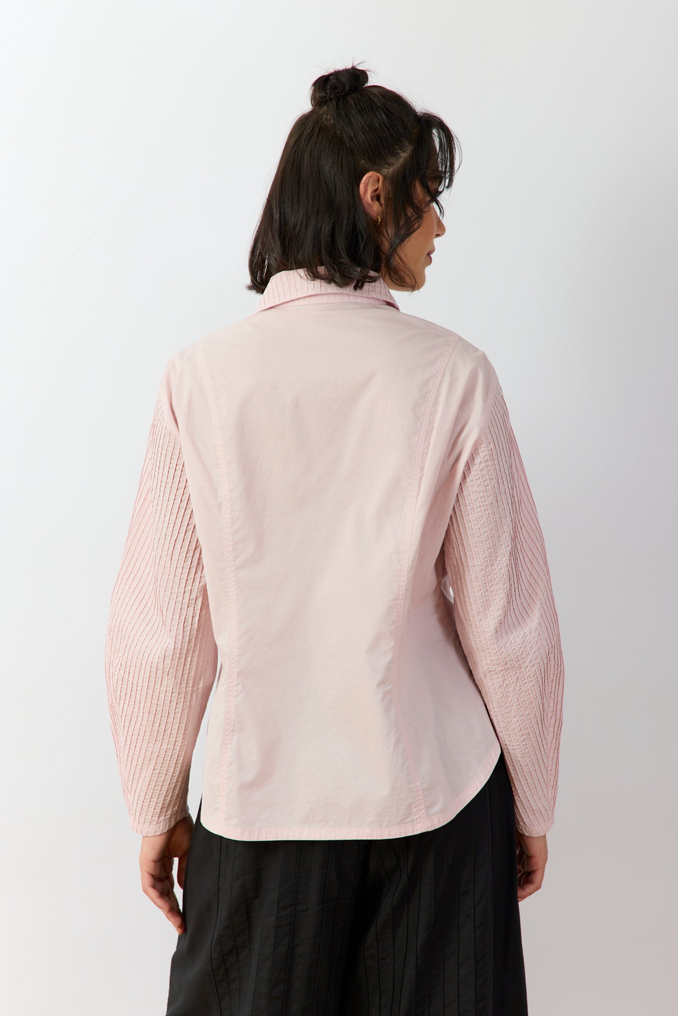 Back view of Yacco Maricard Wanda Shirt highlighting the alternating panels of smooth and finely pintucked cotton in Sakura pink.