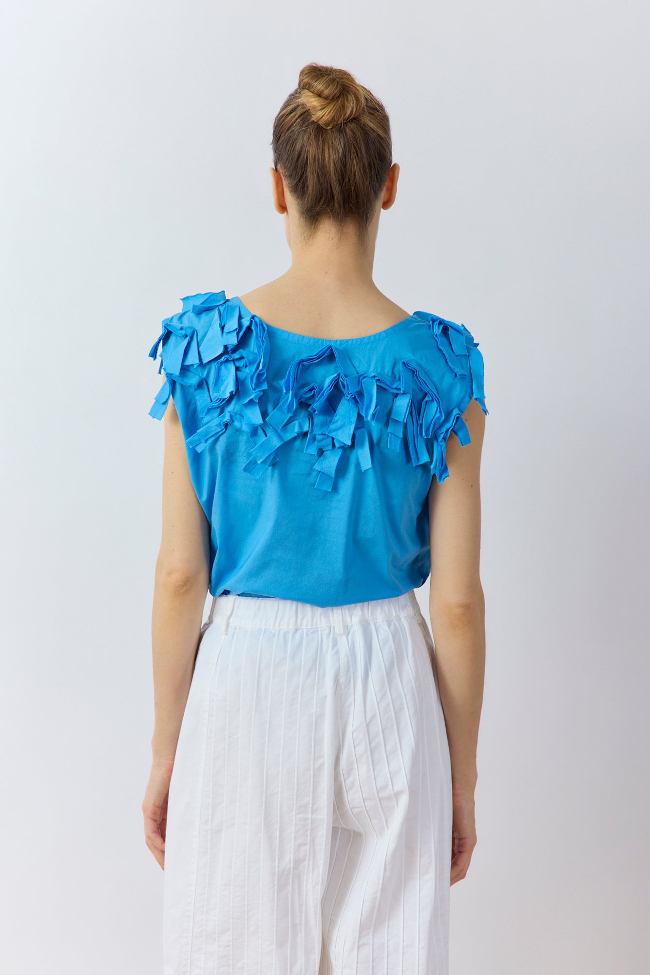 Back view of Yaccomaricard Hane Vest in hana blue with textured lawn ribbon detailing.