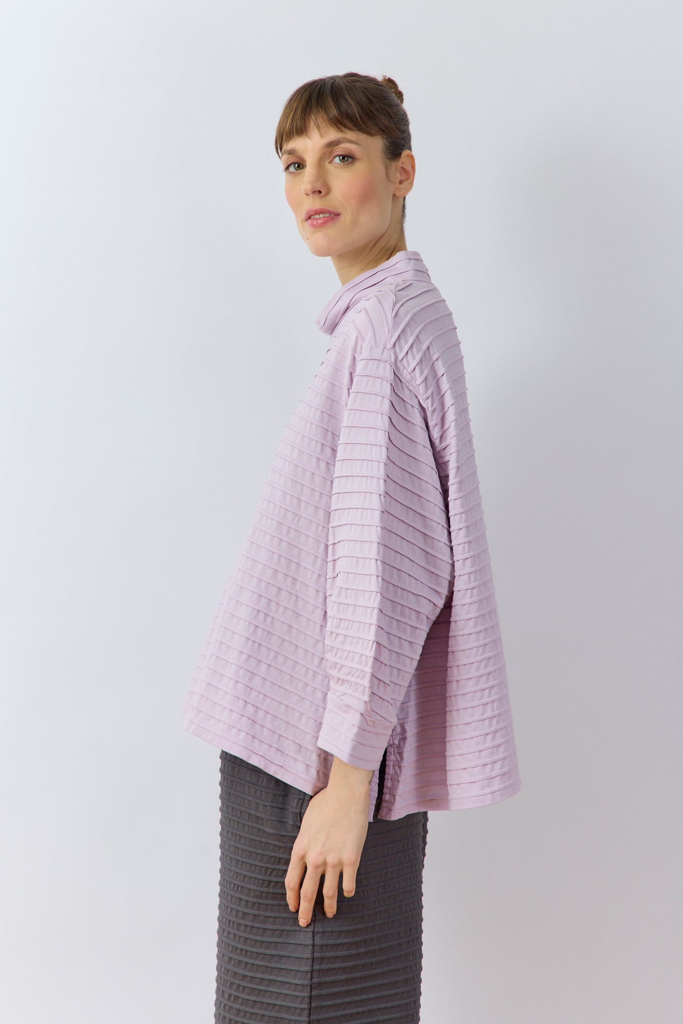 Side profile of Sode Jersey Pullover showing architectural draped sleeve detail in lilac purple.