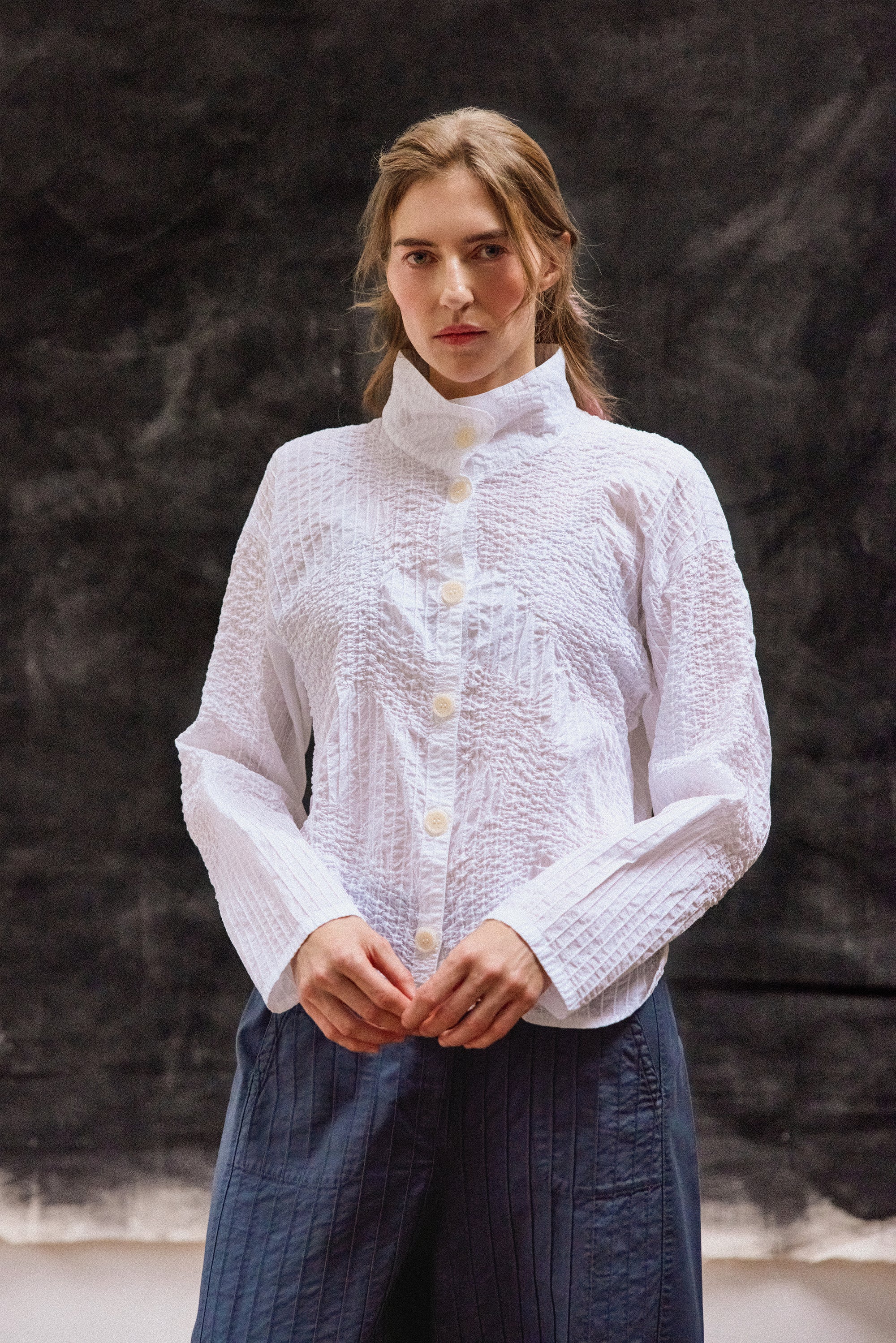 Model wearing white Shibo Jacket with textured pintuck cotton design and relaxed silhouette.